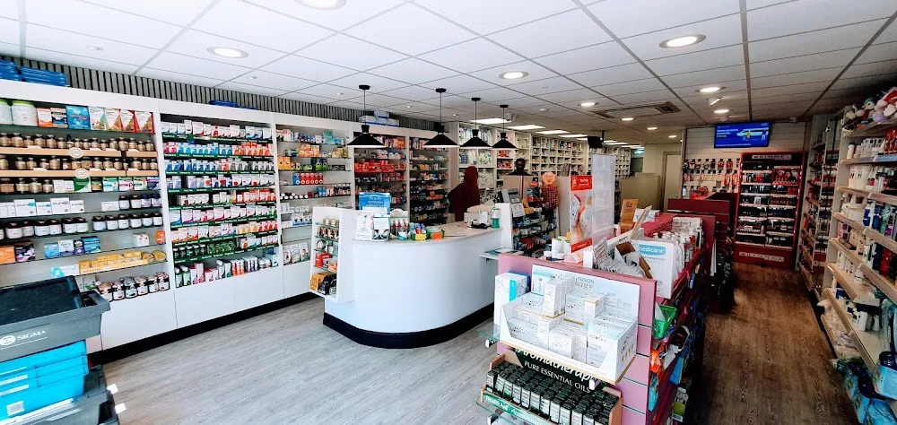 The retail floor of Miles Pharmacy, with shelves of products either side of a curved dispensing counter